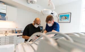 2 stk tannleger jobber på en pasient med å fjerne visdomstann