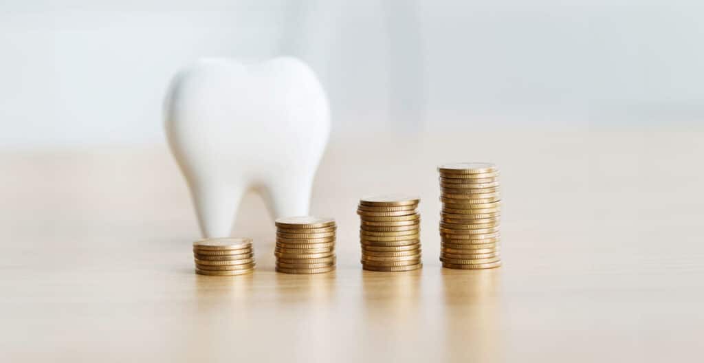 Penger og tann som illustrerer hvem som betaler for tannlegetimen